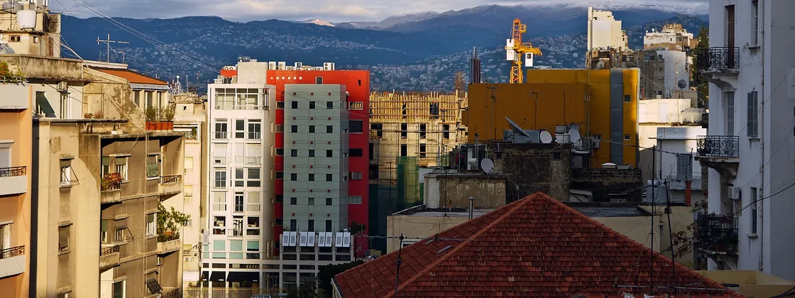 Colourful buildings and red-tiled roofs in Gemmayze, with the mountains behind