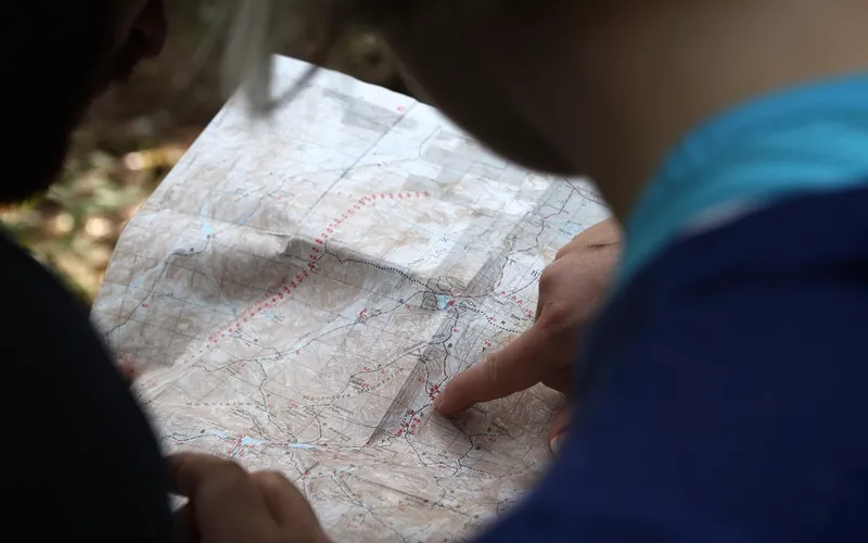 Two people tracing a route on a paper map